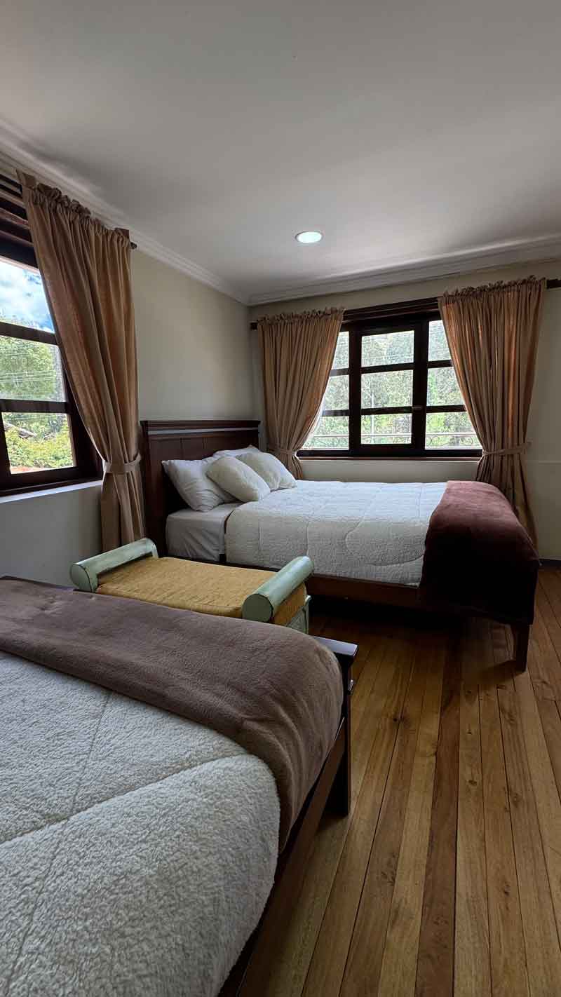Room with two beds and wooden floors